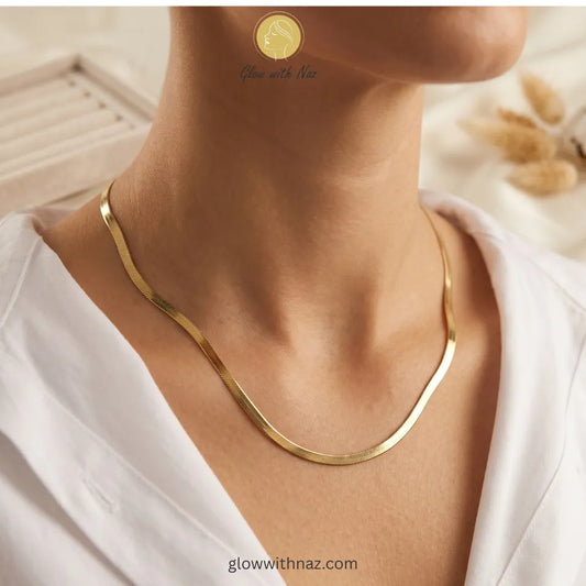 Close-up shot of gold herringbone necklace clasp and texture details