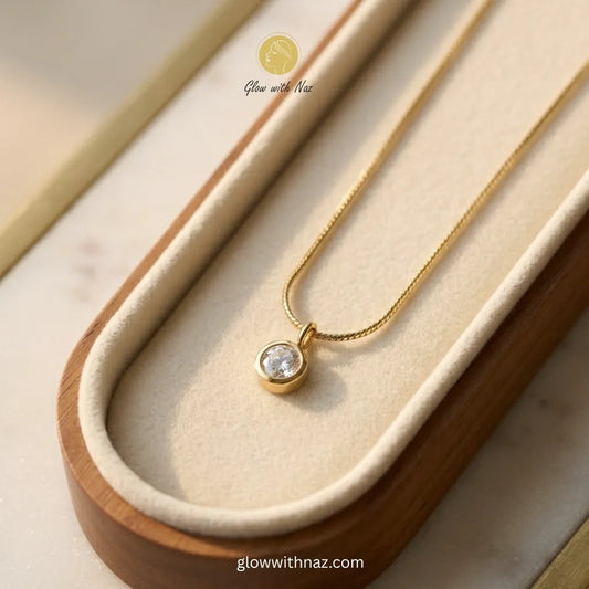 Gold solitaire diamond style round zircon bezel pendant on snake chain necklace in wooden velvet-lined display tray anti-tarnish stainless steel by Glow with Naz