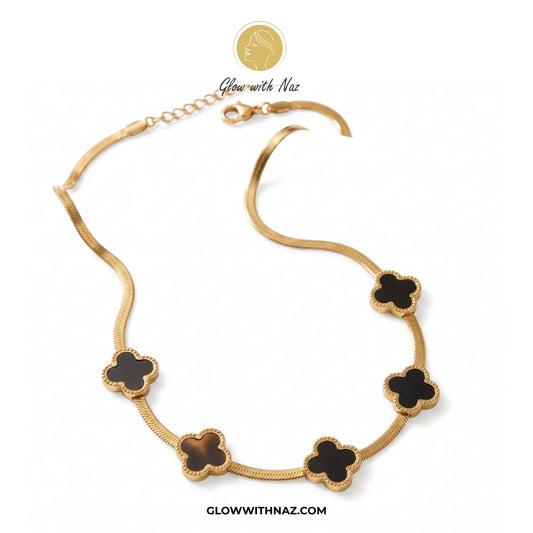 Gold necklace with black clover-shaped pendants on a white background, branded 'Glow with Naz'. Pink tulip Necklace with pink stones on a white plate, brand 'Glow with Naz' visible