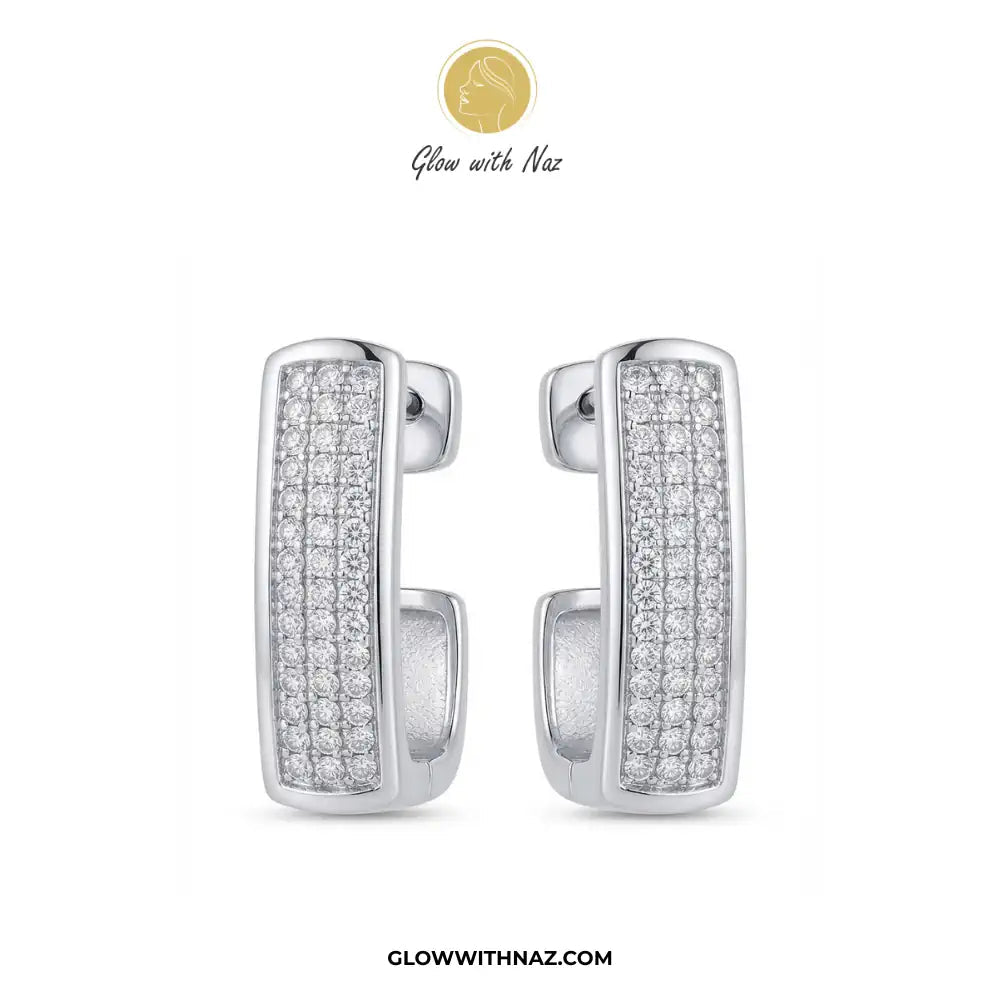 Silver Zircon Square Statement Earring for Women - Silver Zircon Square Statement Earring for WomenJewelryGlow With NazGlow With NazE054A pair of silver huggie hoop earrings paved with clear cubic zirconia stones, shown against a plain white background with the brand logo 'Glow with Naz' at the top and the website 'GLOWWITHNAZ.COM' at the bottom.