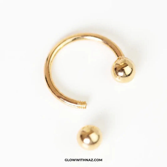 Stainless Steel Horseshoe 8.5 mm C Nose Ring & Helix Ear Piercing Jewelry - Stainless Steel Horseshoe 8.5 mm C Nose Ring & Helix Ear Piercing JewelryJewelryGlow With NazGlow With NazNR004A gold-colored curved barbell piercing stud with a ball end, shown on a plain white background with a separate matching ball end below it. The text 'GLOWWITHNAZ. nose ring, helix piercing jewelry, cartilage earring, horseshoe piercing, septum ring, stainless steel jewelry, body jewelry, hypoallergenic nose ring,