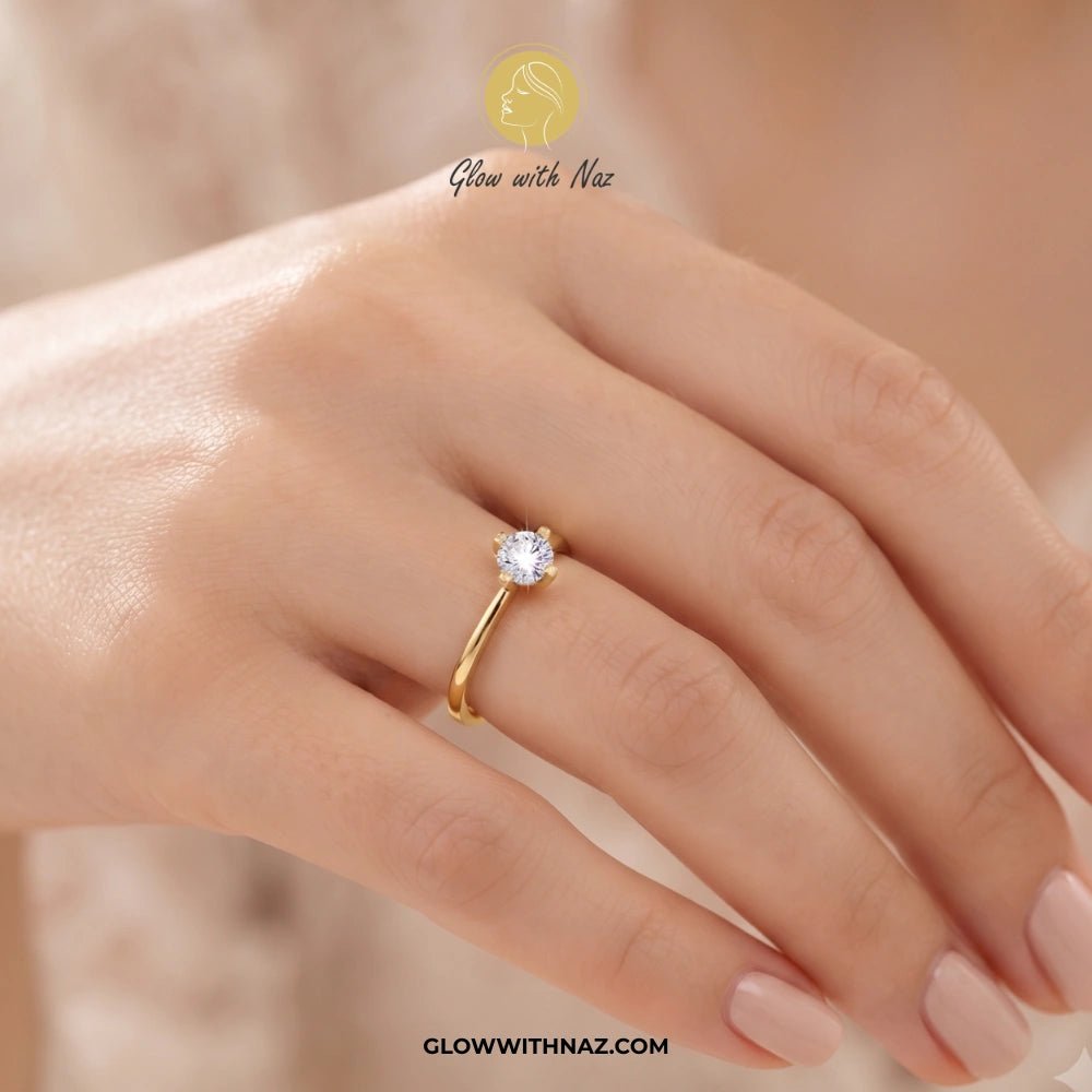 Timeless 4 Grip Diamond Ring for Women - Timeless 4 Grip Diamond Ring for WomenJewelryGlow With NazGlow With NazA gold solitaire ring with a clear round gemstone worn on a woman's finger. The image features a warm, soft-focus background and a brand watermark 'Glow with Naz' at the top and 'GLOWWITHNAZ. ring, girls rings, rings for girls, rings simple, simple rings, stainless steel jewelry, jewellery set, aesthetic jewelry, simple jewellery, chain, jewelry, artificial jewellery