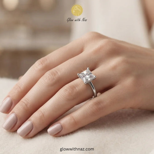 Timeless Adjustable Silver Big Square Diamond Ring - Timeless Adjustable Silver Big Square Diamond RingJewelryGlow With NazGlow With NazR026A silver ring with a clear princess-cut gemstone worn on a hand with light pink manicured nails, set against a soft beige background with a 'Glow with Naz' watermark. ring, girls rings, rings for girls, rings simple, simple rings, stainless steel jewelry, jewellery set, aesthetic jewelry, simple jewellery, chain, jewelry, artificial jewellery