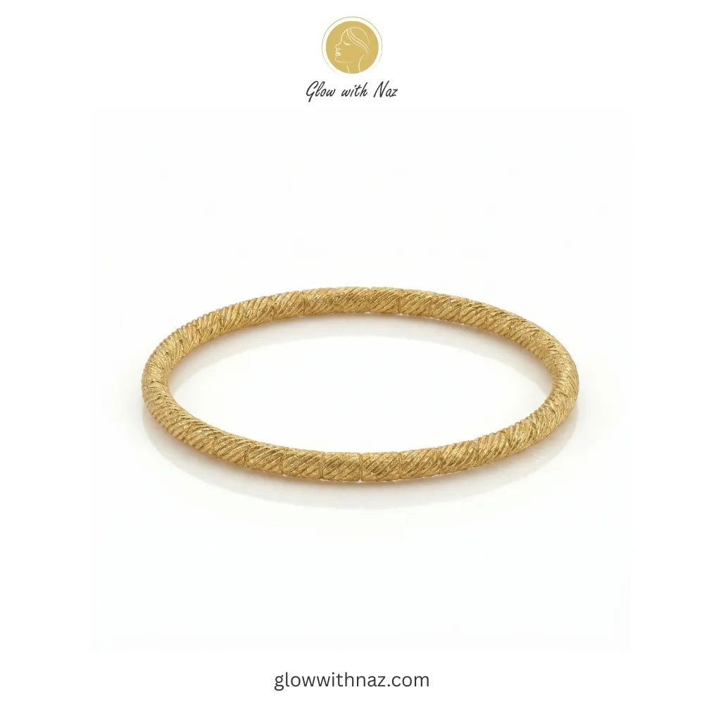 Angled view showing the craftsmanship of the twisted gold bangle