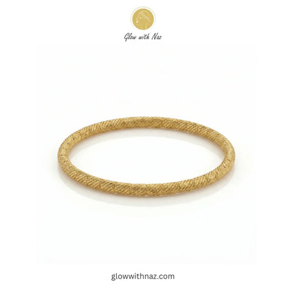 Angled view showing the craftsmanship of the twisted gold bangle