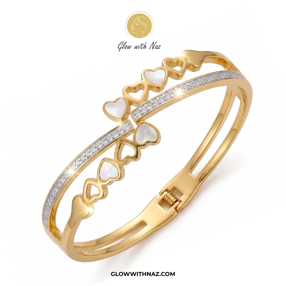 Gold bracelet with heart designs and gemstones on a white background