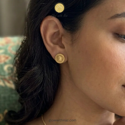 Bold gold studs displayed to highlight their statement size and detailed motif