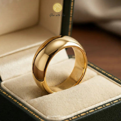 Close-up of a chunky gold dome ring being worn as a statement piece or stacked with other rings.