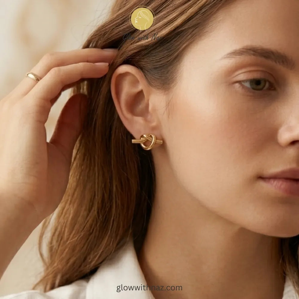 Close-up detail of the intricate knot design on gold stud earrings