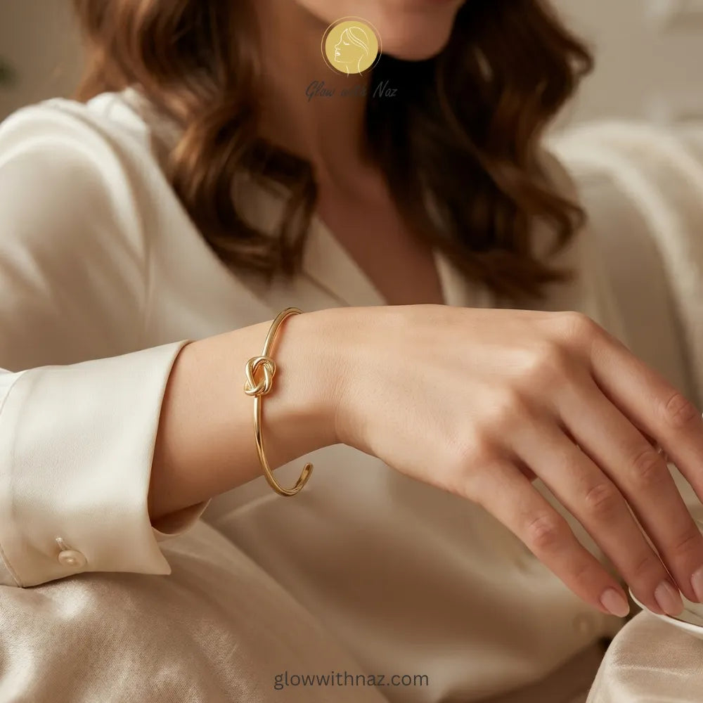 Close-up view of polished gold knot detail on cuff bracelet