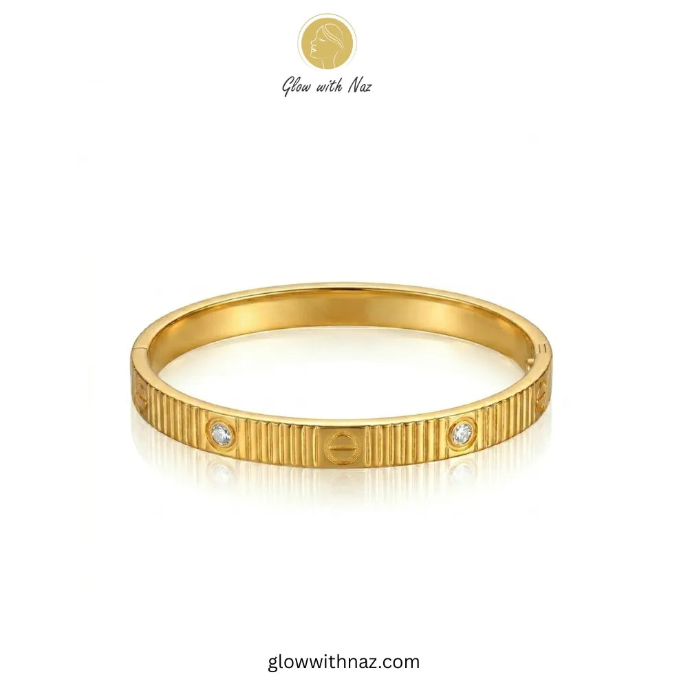 Close-up view of ribbed texture and stones on gold bangle