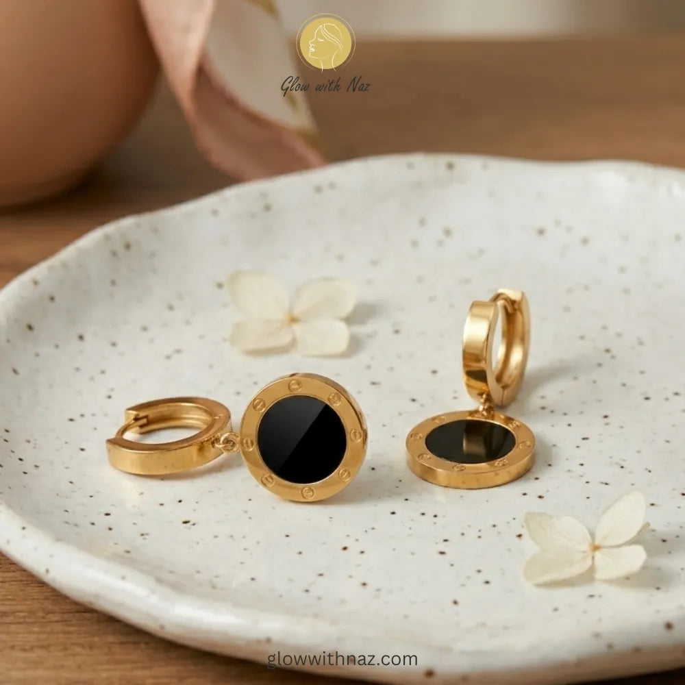 Detailed front view of high-shine gold and black inlay earrings