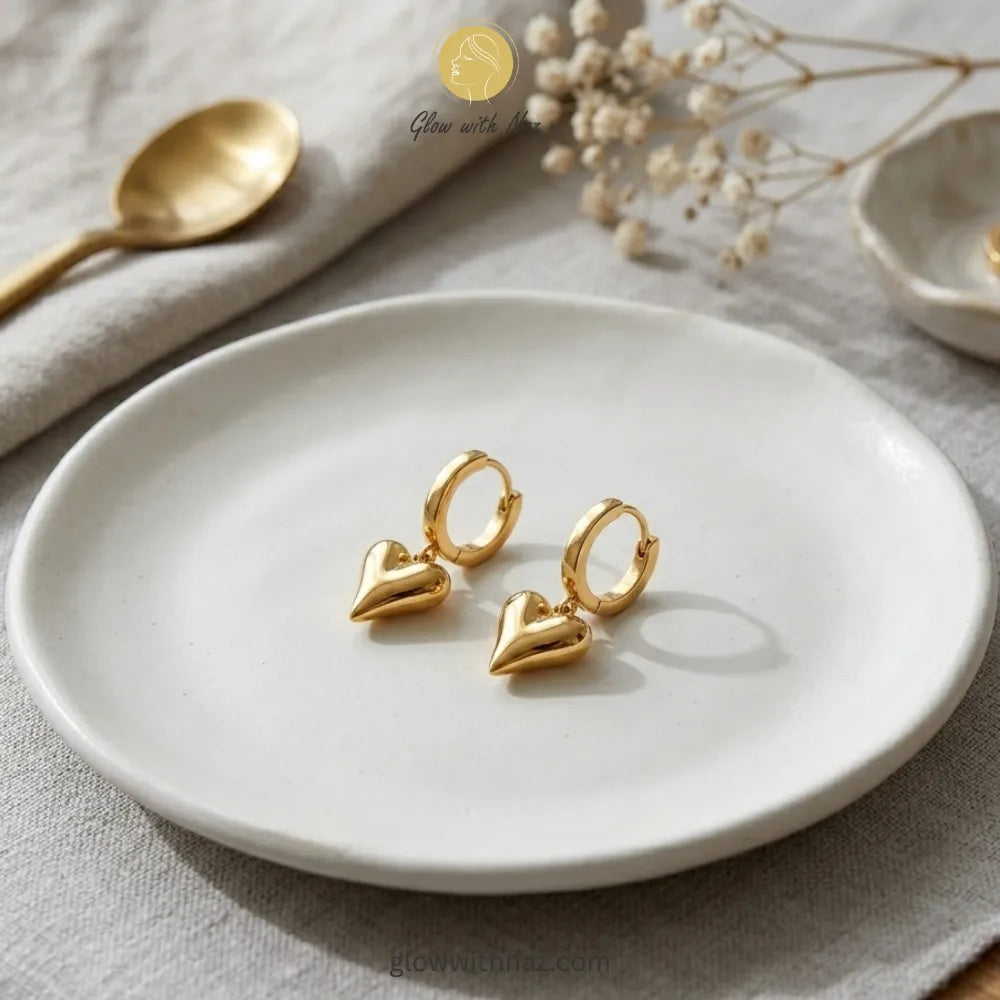 Detailed front view of high-shine gold heart drop earrings