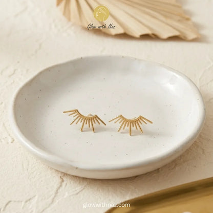 Detailed front view of high-shine gold sunburst stud earrings
