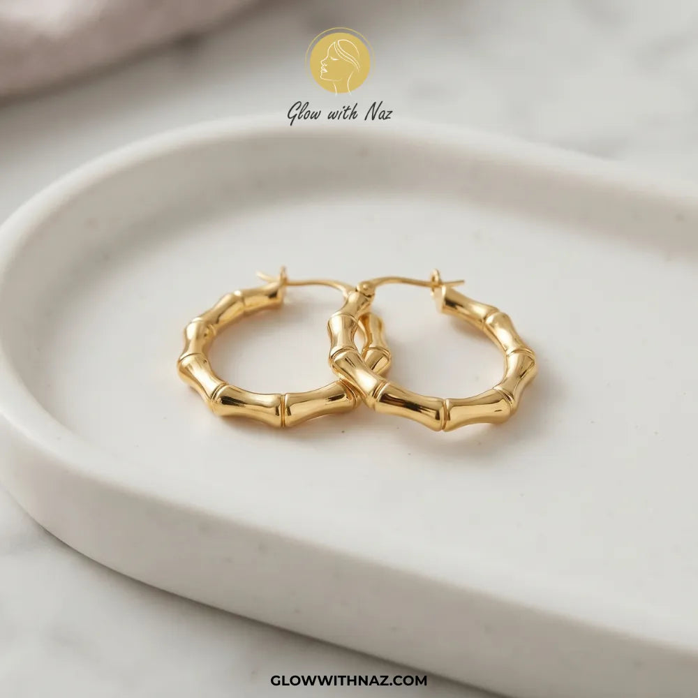 Gold plated stainless steel bamboo bone segment jointed hoop earrings with latch closure by Glow With Naz