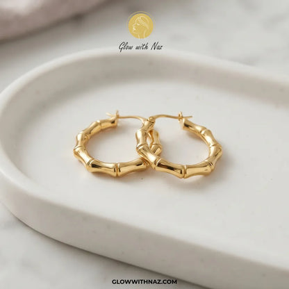 Gold plated stainless steel bamboo bone segment jointed hoop earrings with latch closure by Glow With Naz