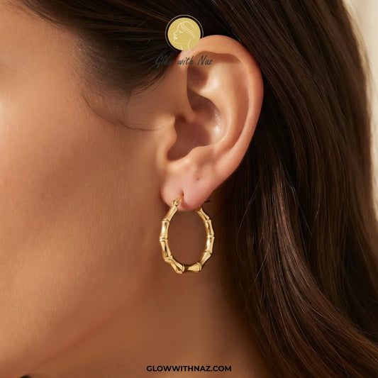 Gold plated stainless steel bamboo bone segment jointed hoop earrings with latch closure by Glow With Naz