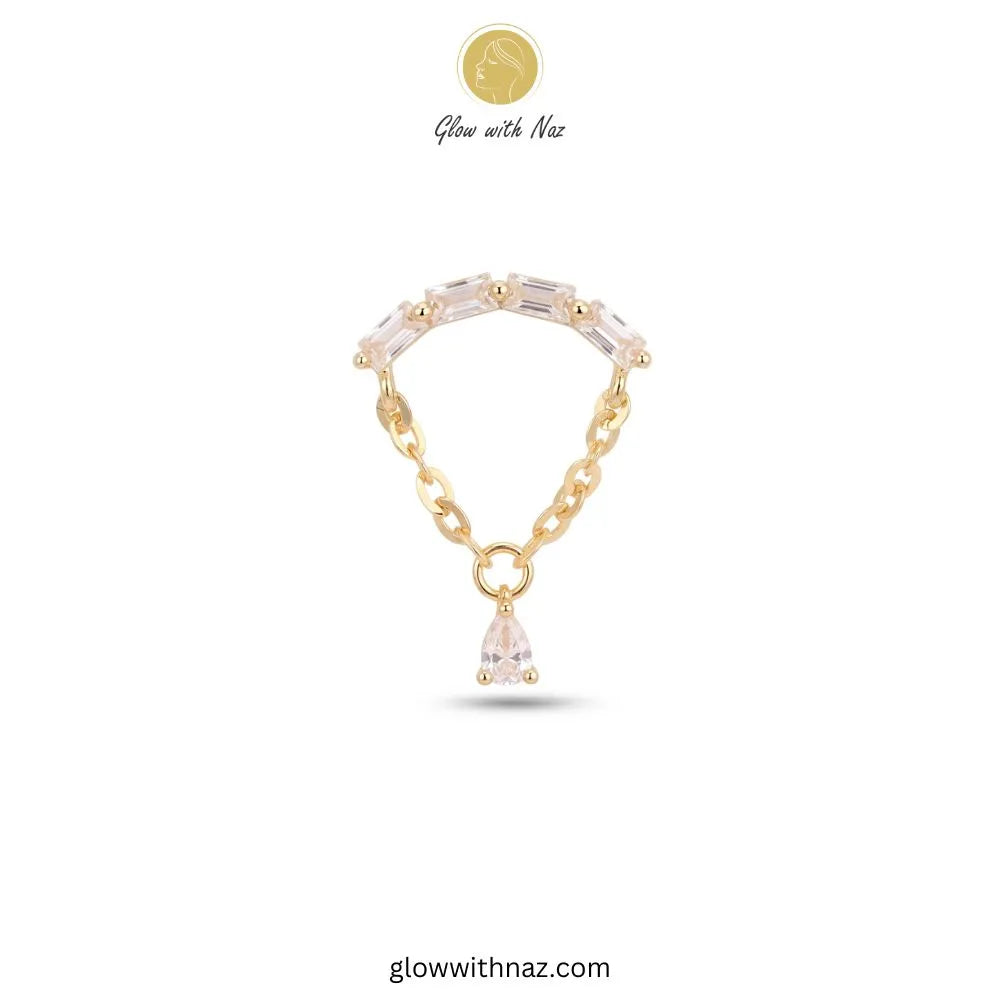 A gold chain bracelet featuring a curved row of clear teardrop-shaped crystals and a dangling clear crystal pendant, shown on a white background with the brand name Glow with Naz.
