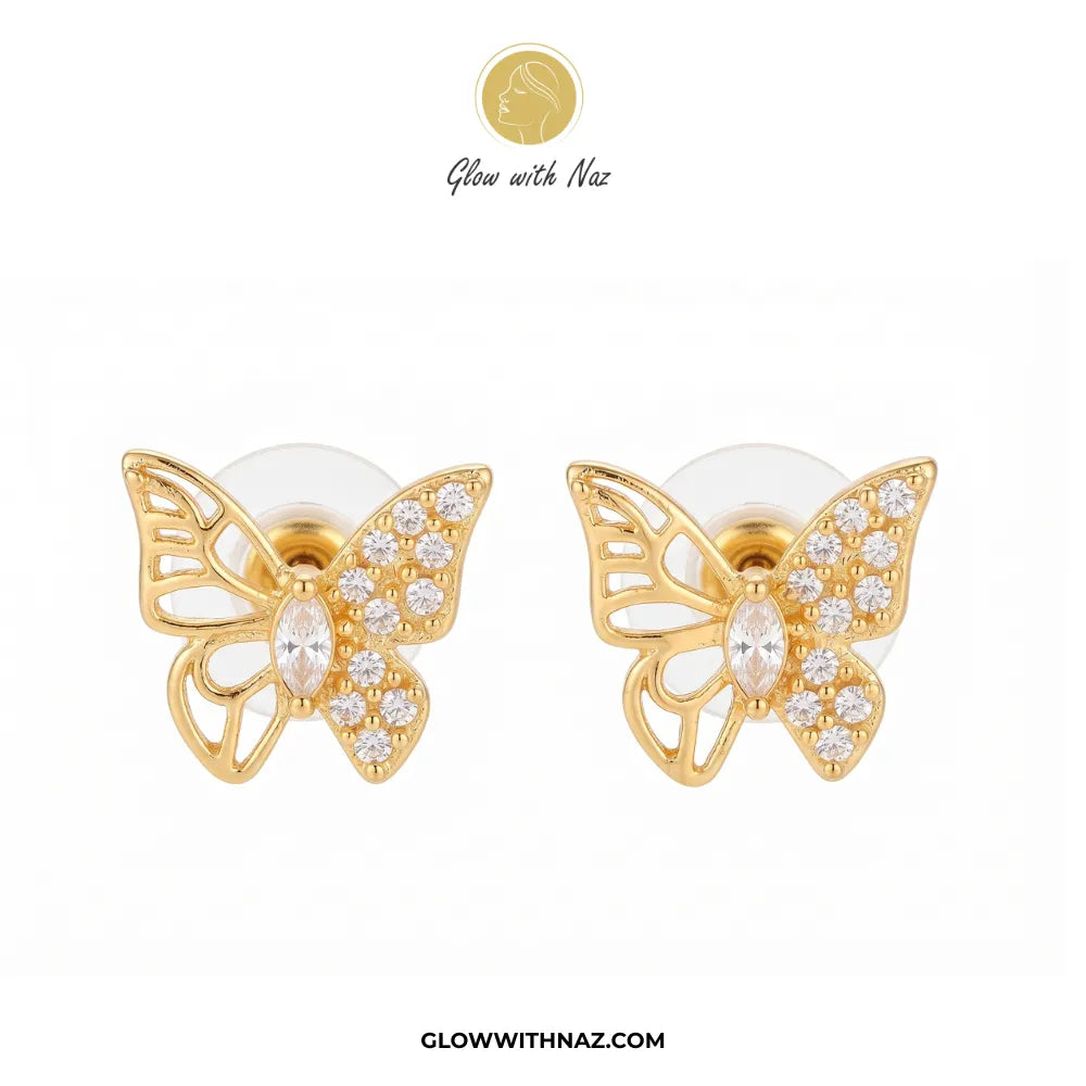 A pair of gold butterfly stud earrings adorned with clear crystals, displayed on a clean white background with the brand logo 'Glow with Naz' at the top and the website 'GLOWWITHNAZ.COM' at the bottom.