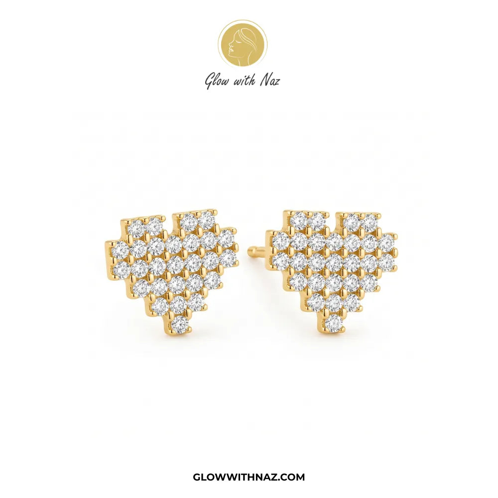 A pair of gold heart-shaped stud earrings paved with clear cubic zirconia stones, displayed on a clean white background with the brand logo 'Glow with Naz' at the top and website URL at the bottom.