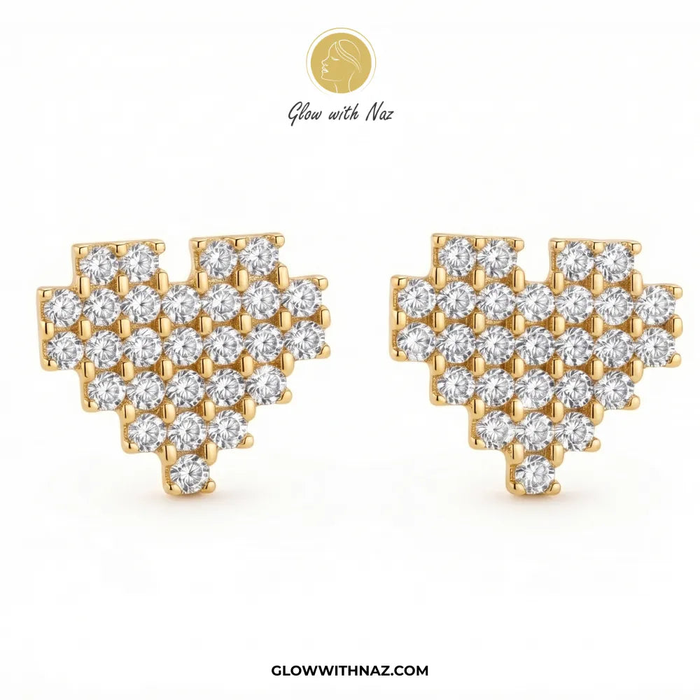 A pair of gold heart-shaped stud earrings set with round-cut clear gemstones, displayed on a clean white background with the brand logo 'Glow with Naz' at the top and 'GLOWWITHNAZ.COM' at the bottom.