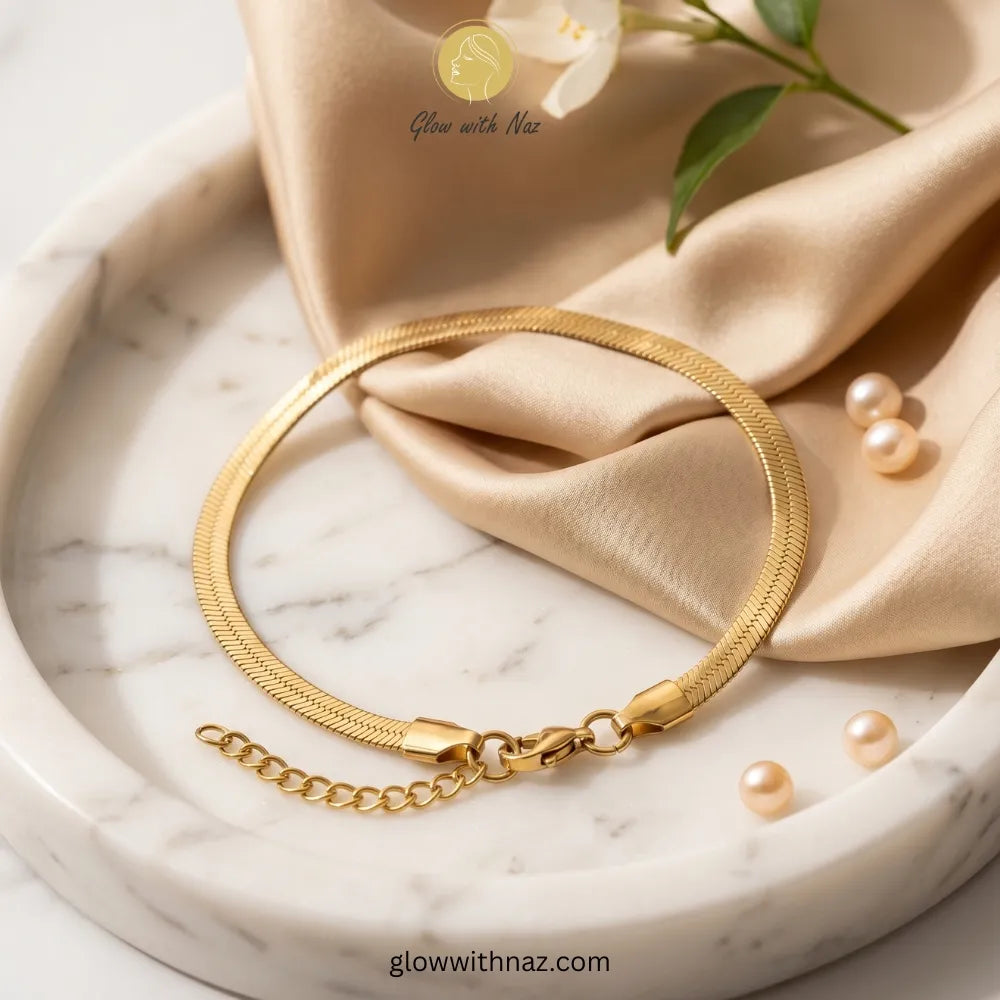 Elegant gold-plated herringbone chain bracelet on model wrist by Glow with Naz