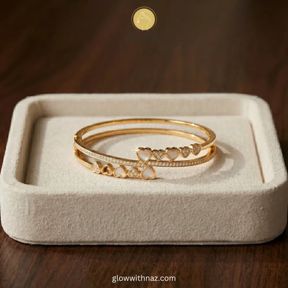 Elegant minimalist jewelry showcasing a stunning gold-plated stainless steel bracelet featuring mother-of-pearl and crystal hearts.