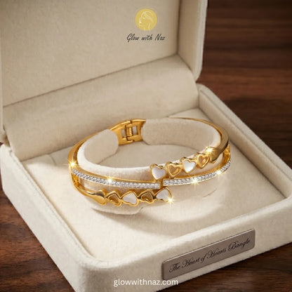 Glow With Naz viral trending gold double-band heart bangle bracelet crafted in stainless steel on a luxury cream jewelry display pad