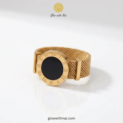 Elegant gold band ring featuring intricate Roman numerals and a black enamel mesh inlay.