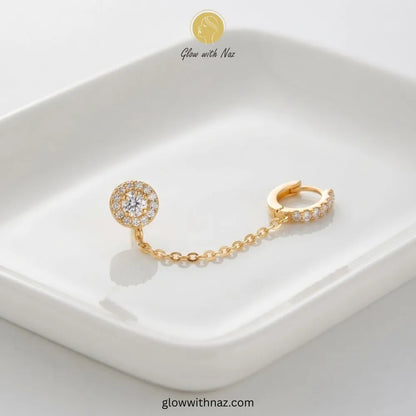 Gold double piercing chain earring connecting a CZ pave huggie hoop to a halo stud for lobe to helix cartilage by Glow With Naz