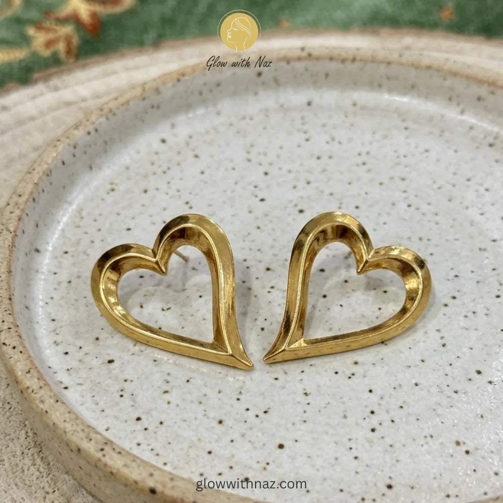 Gold heart earrings displayed to showcase their minimalist shape and size