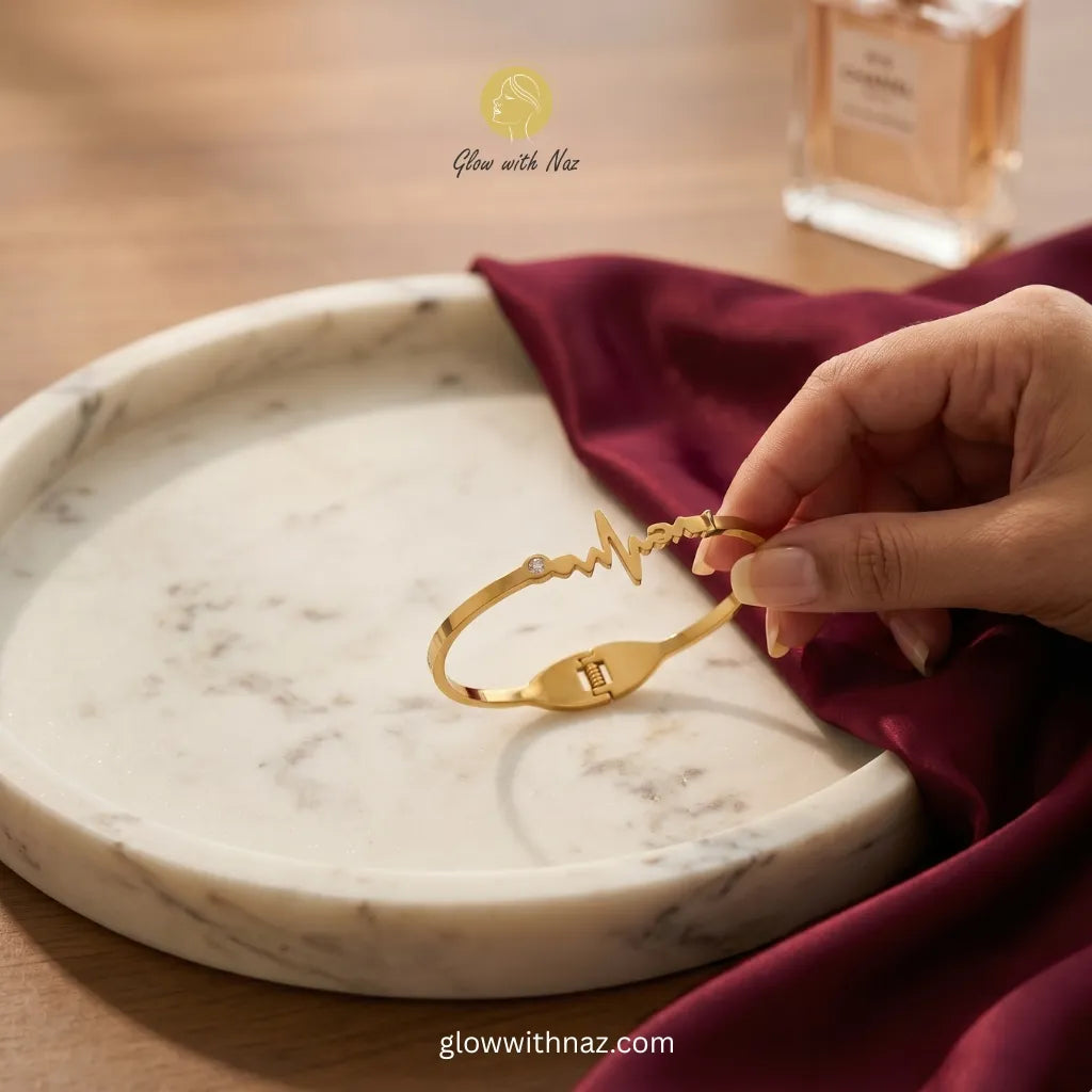 Gold heartbeat ECG bracelet with zircon stone held over marble tray — anti-tarnish stainless steel bangle online in Pakistan by Glow with Naz
