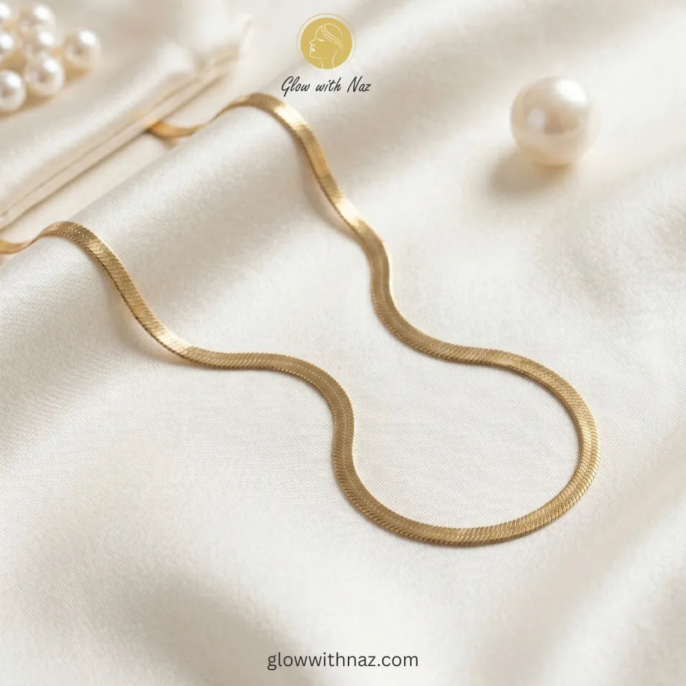 Gold herringbone chain necklace stacked with luxury jewelry accessories