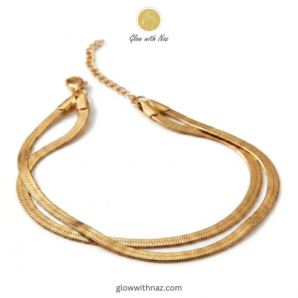 Layered herringbone bracelet stacked with luxury wrist accessories