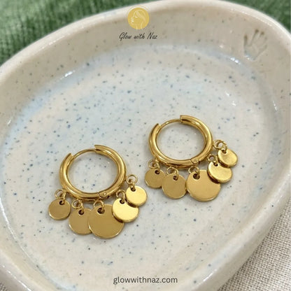 Lifestyle shot of modern coin charm hoop earrings for a stylish statement look
