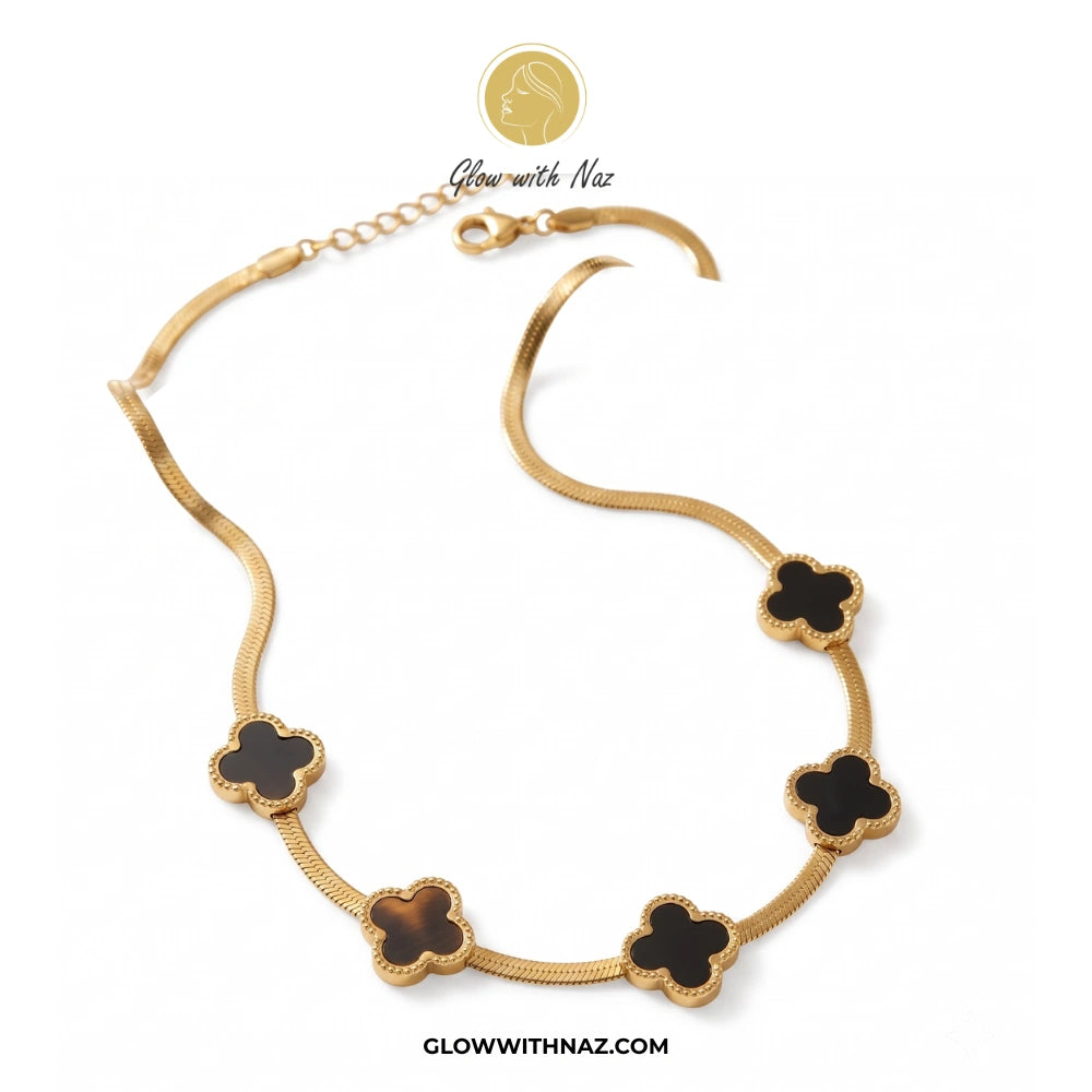 Gold necklace with black clover-shaped pendants on a white background, branded 'Glow with Naz'. Pink tulip Necklace with pink stones on a white plate, brand 'Glow with Naz' visible