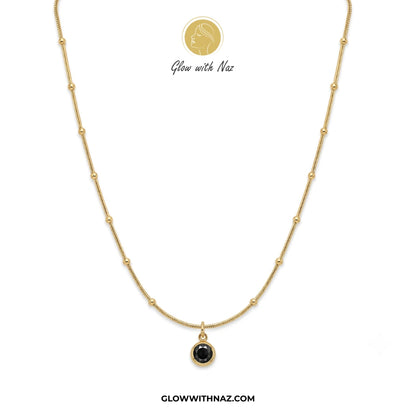 Gold necklace with a black pendant on a white background, branded 'Glow with Naz'. necklace, pendant necklace, necklace set, locket set, simple necklace, pendant set, pendant, chain necklace, diamond pendant, diamond necklace, locket necklace, neck chain, girls locket, heart locket, pendant for girls, necklace for girls, heart necklace, locket for girls, diamond locket, pendant necklace for girls, heart chain locket, stainless steel necklace, double chain necklace, ruby necklace, neck chain for girls, locke