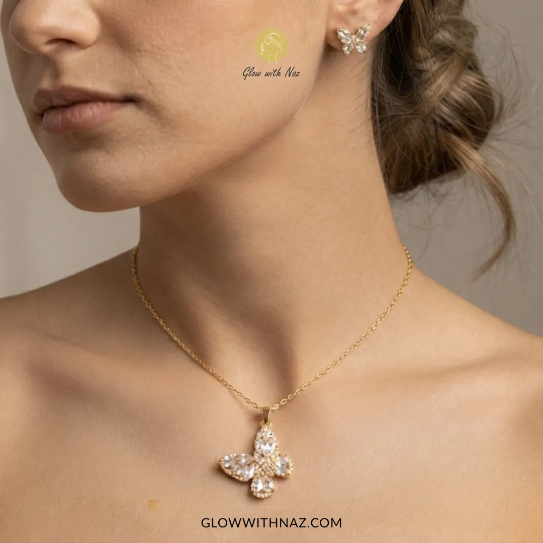 A close-up lifestyle shot of a model wearing a gold necklace with a flower-shaped crystal pendant and a matching butterfly stud earring. The brand name 'Glow with Naz' is visible as a watermark on the cheek and in the URL at the bottom.