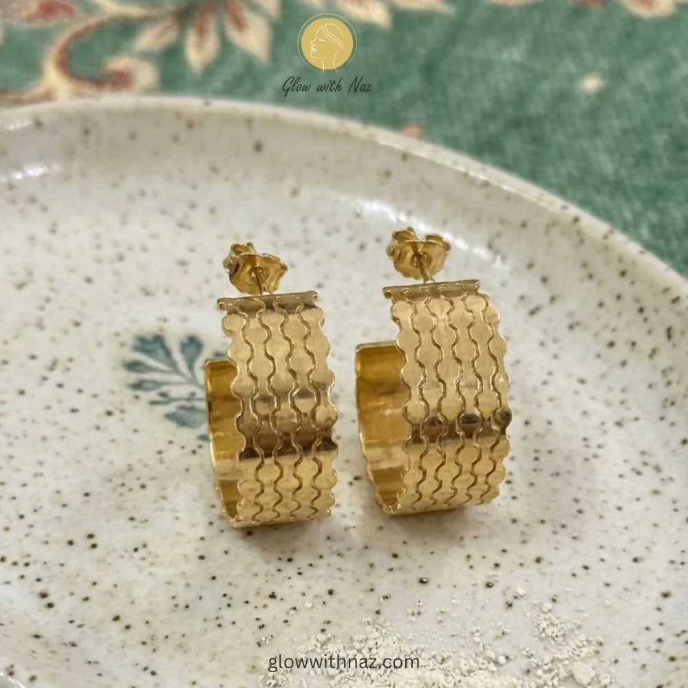 Pair of elegant gold-tone open hoop earrings with a detailed layered wave texture