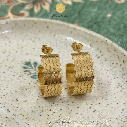 Pair of elegant gold-tone open hoop earrings with a detailed layered wave texture
