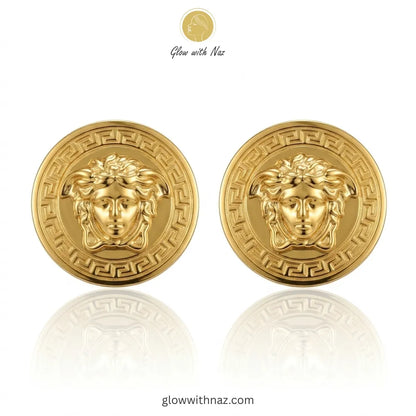 Pair of iconic medusa-inspired gold stud earrings with greek key border against white background