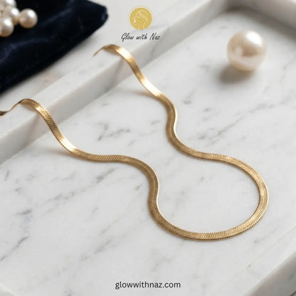 Premium gold herringbone necklace displayed on a luxury jewelry tray