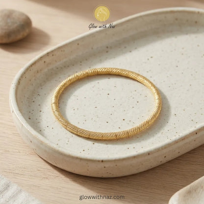 Premium twisted gold bangle packaged as a gift