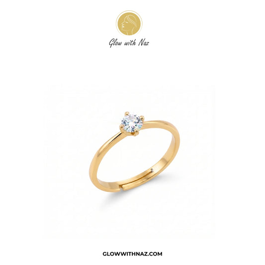 A yellow gold solitaire ring with a round-cut clear gemstone, displayed on a clean white background with the brand logo 'Glow with Naz' at the top and the website 'GLOWWITHNAZ.COM' at the bottom.

ring, girls rings, rings for girls, rings simple, simple rings, stainless steel jewelry, jewellery set, aesthetic jewelry, simple jewellery, chain, jewelry, artificial jewellery