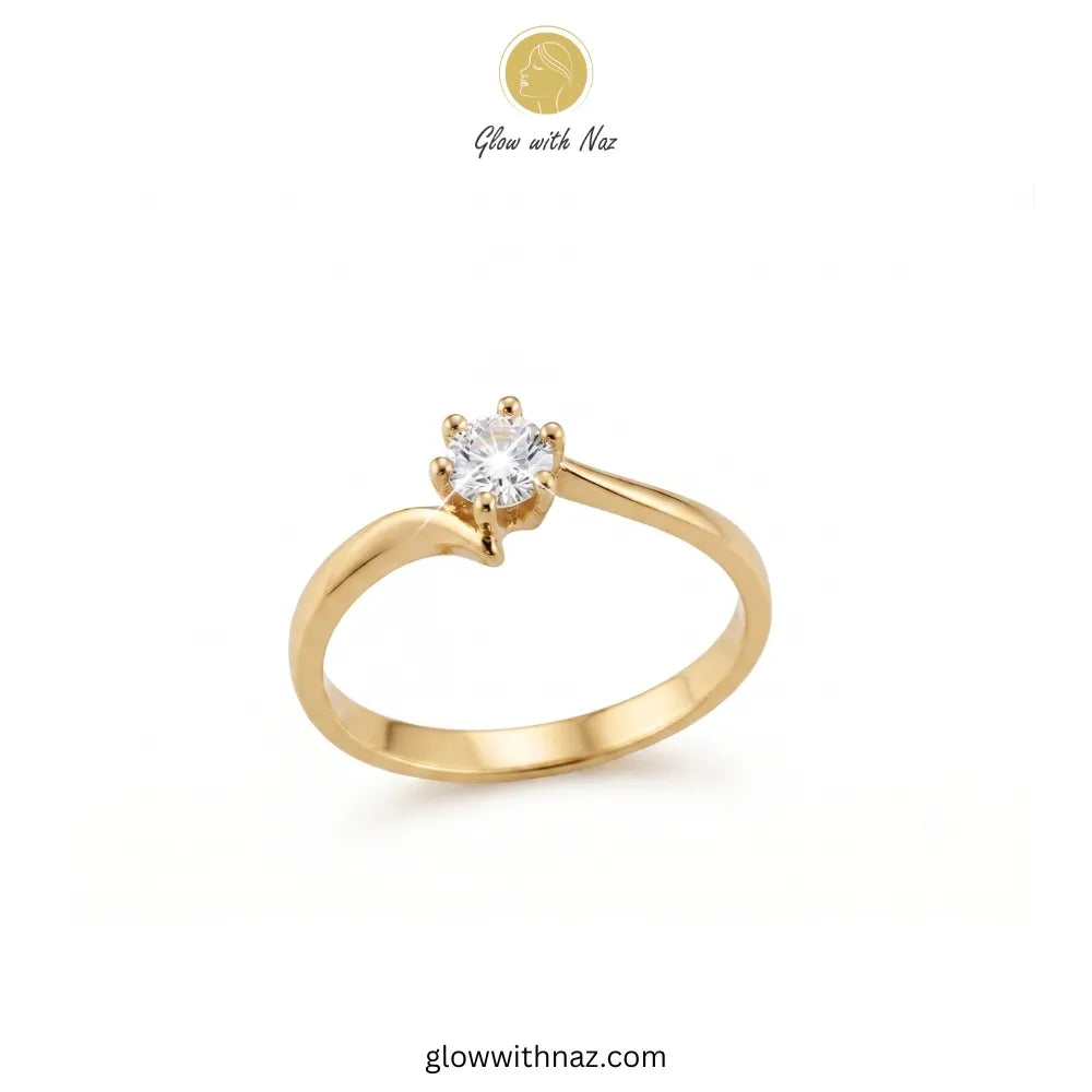 A yellow gold solitaire engagement ring with a round-cut clear gemstone in a prong setting, shown on a plain white background with Glow with Naz branding.