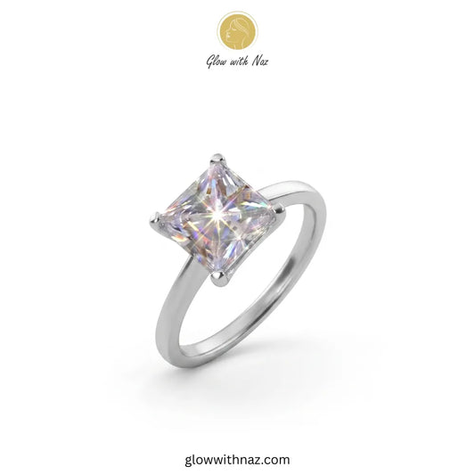 A silver-toned ring with a square iridescent gemstone, shown on a plain white background with a small 'Glow with Naz' logo at the top and the website at the bottom ring, girls rings, rings for girls, rings simple, simple rings, stainless steel jewelry, jewellery set, aesthetic jewelry, simple jewellery, chain, jewelry, artificial jewellery