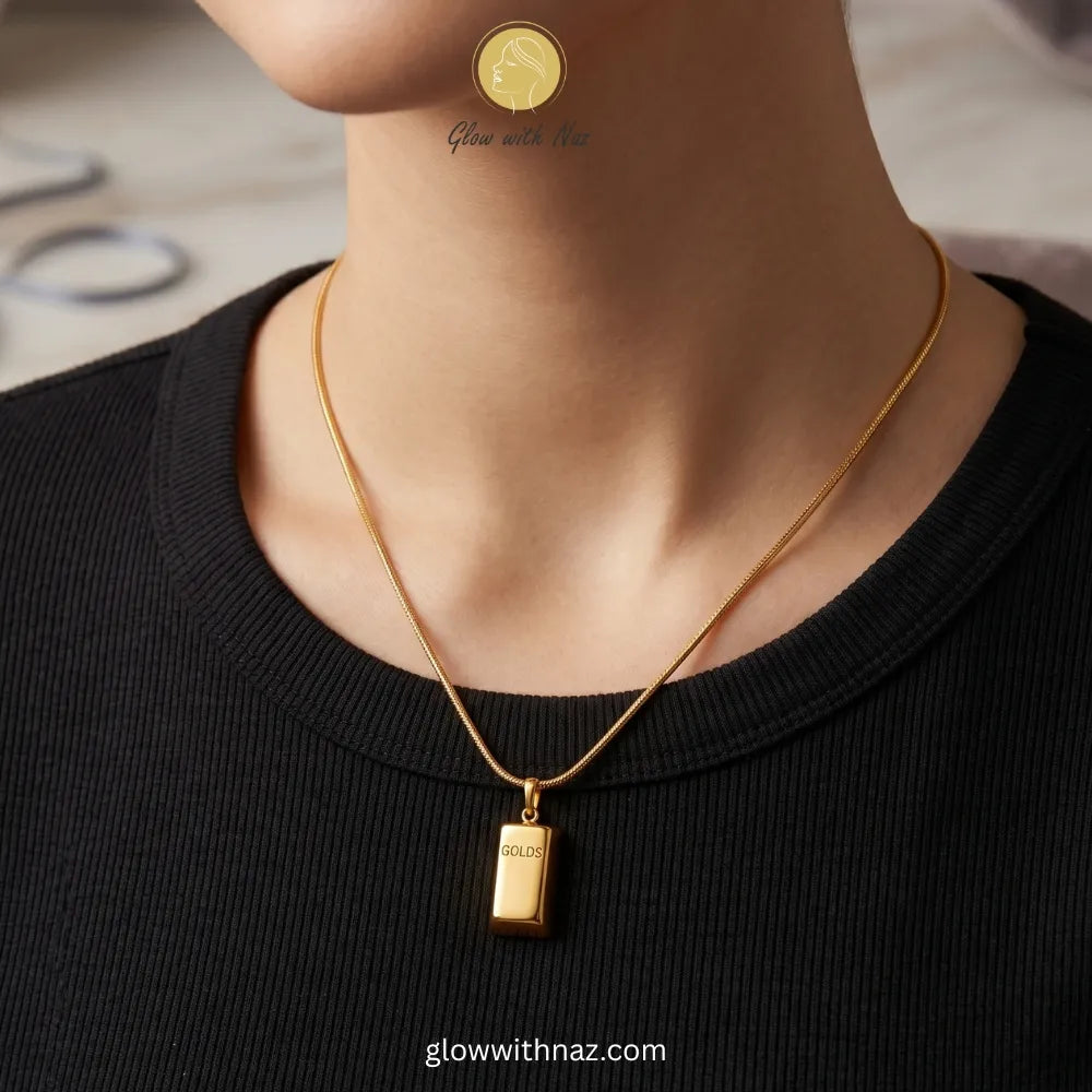 Close-up of gold bar pendant engraving and chain connection