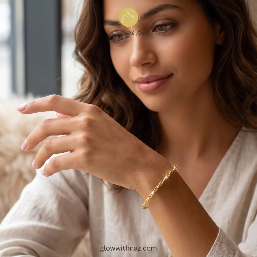 Twisted gold cuff stacked with luxury wrist accessories