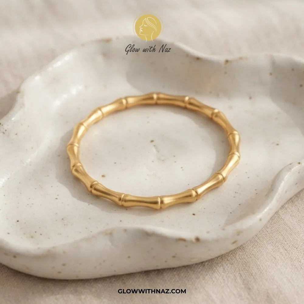 Gold bamboo joint cuff bangle displayed in a white ceramic tray by Glow With Naz