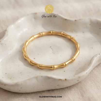 Gold bamboo joint cuff bangle displayed in a white ceramic tray by Glow With Naz